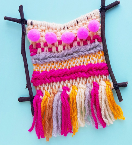 twig frame weaving with pink, orange, white yarn 